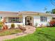 Charming home with lush landscaping and a welcoming brick pathway to the front door at 7460 Dickens Dr, Sarasota, FL 34231