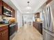 Well-lit kitchen featuring stainless steel appliances, dark wood cabinetry, and tile flooring throughout at 7460 Dickens Dr, Sarasota, FL 34231