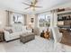 A sunlit living room features a sofa, decorative ceiling fan, many windows and a woven coffee table at 7460 Dickens Dr, Sarasota, FL 34231
