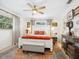 A bright main bedroom featuring a ceiling fan, a large bed with orange accents, and an area rug at 7460 Dickens Dr, Sarasota, FL 34231