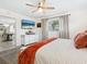 A cozy main bedroom with a mounted television, patterned rug, and view into the dining area at 7460 Dickens Dr, Sarasota, FL 34231