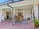 Spacious brick paved patio with dining table, ceiling fan, privacy curtains, and access to screened pool at 7460 Dickens Dr, Sarasota, FL 34231