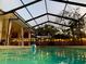 Inviting screened-in pool with string lights and a covered patio area with comfortable seating, ideal for relaxation and entertainment at 7460 Dickens Dr, Sarasota, FL 34231