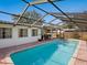 Sparkling pool with screened enclosure, brick paver deck, and a view of the well maintained yard at 7460 Dickens Dr, Sarasota, FL 34231
