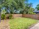 Well maintained grass yard with wood fence, large trees, and brick-paved walkway on edge of yard at 7460 Dickens Dr, Sarasota, FL 34231