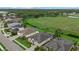 Overhead view of homes backing onto a lush green space and pond, with manicured lawns at 7744 Castleisland Dr, Sarasota, FL 34240