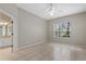 Bright, neutral bedroom featuring ceiling fan, tile floors, and natural light at 7744 Castleisland Dr, Sarasota, FL 34240