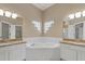 Bright ensuite bathroom with dual sinks, granite counters and jacuzzi tub at 7744 Castleisland Dr, Sarasota, FL 34240