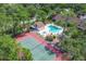 A beautiful aerial view showcases the pool, hot tub, and tennis court amidst lush greenery at 7915 4Th W Ave # 7915, Bradenton, FL 34209