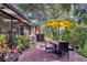 Beautiful backyard featuring a brick patio, lush landscaping, and a yellow umbrella-covered dining area at 7915 4Th W Ave # 7915, Bradenton, FL 34209