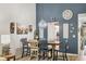 Dining room with elegant chandelier, custom blue wall, and view into the kitchen at 7915 4Th W Ave # 7915, Bradenton, FL 34209
