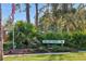 Community sign amidst lush landscaping and mature trees welcoming you home at 7915 4Th W Ave # 7915, Bradenton, FL 34209