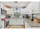 Bright kitchen with white cabinetry, granite countertops, stainless steel appliances, and a window view at 7915 4Th W Ave # 7915, Bradenton, FL 34209
