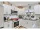 Bright kitchen featuring white cabinets, granite countertops, stainless appliances, and a view from the window at 7915 4Th W Ave # 7915, Bradenton, FL 34209