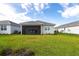 Spacious backyard with green grass, a covered patio, and a serene view of neighboring homes at 8148 Sternway Rd, Sarasota, FL 34240