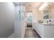 Bright bathroom with a tiled shower, modern vanity, and wood-look floors; the doorway shows into the bedroom at 8148 Sternway Rd, Sarasota, FL 34240