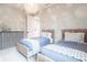 Bright bedroom boasts two twin beds, a chandelier, and a gray accent cabinet with decorative starfish at 8148 Sternway Rd, Sarasota, FL 34240