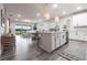 Modern kitchen with white cabinets, a large island, and stainless steel appliances open to living space at 8148 Sternway Rd, Sarasota, FL 34240