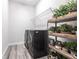 Well-organized laundry room with modern machines, decorative plants, and a wire rack shelf at 8148 Sternway Rd, Sarasota, FL 34240