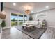 Bright living room with a large sliding glass door, stylish furniture, and view of the lake at 8148 Sternway Rd, Sarasota, FL 34240