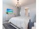 This main bedroom features a TV, white furniture, neutral bedding, and an ensuite bathroom and closet at 8148 Sternway Rd, Sarasota, FL 34240