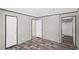 Bedroom with wood-look flooring featuring two entryways and neutral colored walls at 8426 Sweden Blvd, Punta Gorda, FL 33982