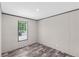 Bright bedroom featuring wood-look flooring and a window providing natural light at 8426 Sweden Blvd, Punta Gorda, FL 33982