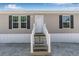 Exterior shot of the home with white trim, siding, and a wooden staircase at 8426 Sweden Blvd, Punta Gorda, FL 33982