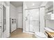 Bright bathroom featuring a walk-in shower with glass doors, a white cabinet, and tile flooring at 8437 Nandina Dr, Sarasota, FL 34240