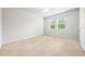 Bright and airy bedroom featuring carpeted floors, two windows, and neutral walls at 8437 Nandina Dr, Sarasota, FL 34240