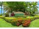 Entrance to Palmer Lake community featuring lush landscaping, colorful flowers, and stone accents at 8437 Nandina Dr, Sarasota, FL 34240