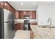 Well-equipped kitchen featuring stainless steel appliances, dark wood cabinetry, and beautiful granite countertops at 8437 Nandina Dr, Sarasota, FL 34240