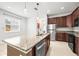 Modern kitchen with stainless steel appliances, granite countertops, and a central island with pendant lighting at 8437 Nandina Dr, Sarasota, FL 34240