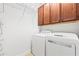 Laundry room featuring a washer, dryer, shelving, and cabinets for storage at 8437 Nandina Dr, Sarasota, FL 34240