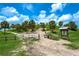 Scenic park entrance with sandy paths, palm trees, information board, and a bike leaning against the gate under a sunny sky at 8437 Nandina Dr, Sarasota, FL 34240