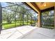 A screened-in patio with concrete flooring provides outdoor living space and views of the landscaped backyard at 8437 Nandina Dr, Sarasota, FL 34240