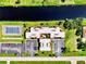 Overhead aerial view of the building with lush landscaping, canal access, and tennis court for a convenient lifestyle at 96 Boundary Blvd # 127, Rotonda West, FL 33947