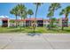 Beautiful multi-Gathering home exterior with lush green grass, palm trees, and a red roof at 96 Boundary Blvd # 127, Rotonda West, FL 33947