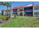 Beautiful exterior of a multi-Gathering home with lush green grass, sign, and a red roof at 96 Boundary Blvd # 127, Rotonda West, FL 33947