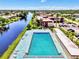 Aerial view of pool near waterway, with palm trees, lush lawns, and buildings nearby at 96 Boundary Blvd # 127, Rotonda West, FL 33947