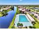Aerial view of pool near waterway, with palm trees, lush lawns, and buildings nearby at 96 Boundary Blvd # 127, Rotonda West, FL 33947