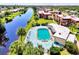 Aerial view of pool near waterway, with palm trees, lush lawns, and buildings nearby at 96 Boundary Blvd # 127, Rotonda West, FL 33947