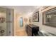 Bright bathroom featuring glass sinks, black cabinet, decorative lighting, marble shower and decorative mirrors and artwork at 988 Blvd Of The Arts # 1016, Sarasota, FL 34236
