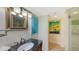 Bathroom features granite countertop vanity, decorative mirror, modern lighting fixtures, and glass shower at 988 Blvd Of The Arts # 1016, Sarasota, FL 34236