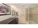 Bright bathroom featuring glass sink, black cabinet, decorative lighting, marble shower and decorative mirrors and artwork at 988 Blvd Of The Arts # 1016, Sarasota, FL 34236