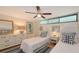 Bedroom with two twin beds, nautical decor, ceiling fan and minimalist design at 988 Blvd Of The Arts # 1016, Sarasota, FL 34236