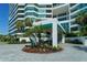 Luxury building entrance with circular driveway, lush landscaping and modern architecture at 988 Blvd Of The Arts # 1016, Sarasota, FL 34236