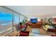 This living room boasts large windows, a mirrored wall, and ocean views with access to the balcony at 988 Blvd Of The Arts # 1016, Sarasota, FL 34236