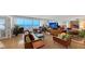 Bright living room features large windows with ocean views, hardwood floors, and stylish mid-century modern furnishings at 988 Blvd Of The Arts # 1016, Sarasota, FL 34236