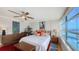 Bright main bedroom with white comforter, colorful decor, wood dresser, ceiling fan and large window with water view at 988 Blvd Of The Arts # 1016, Sarasota, FL 34236